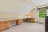 Built-in wood cabinetry with integrated desk space, sloped ceiling detail, and a window with exterior greenery
