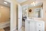Bathroom vanity with a white countertop, undermount sink, and brushed nickel faucet
