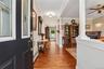 Hardwood flooring, decorative columns, crown molding, a built-in fireplace, and a ceiling fan