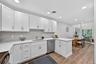 Kitchen with white cabinets, backsplash, dishwasher, black range with electric stovetop, and recessed lighting