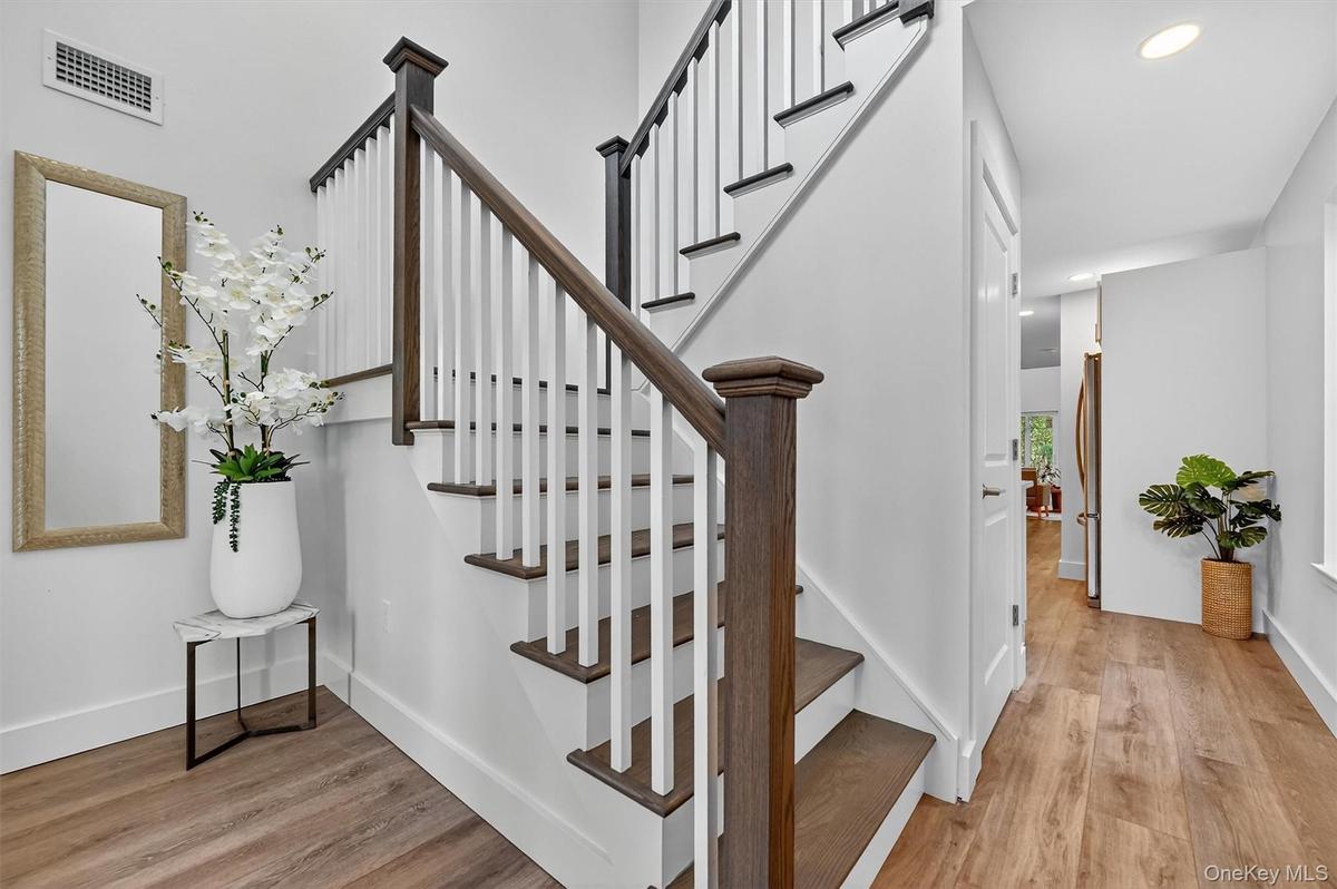 Stairway featuring wood finished floors and recessed lighting