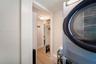 Laundry room leading to closet and out into primary
