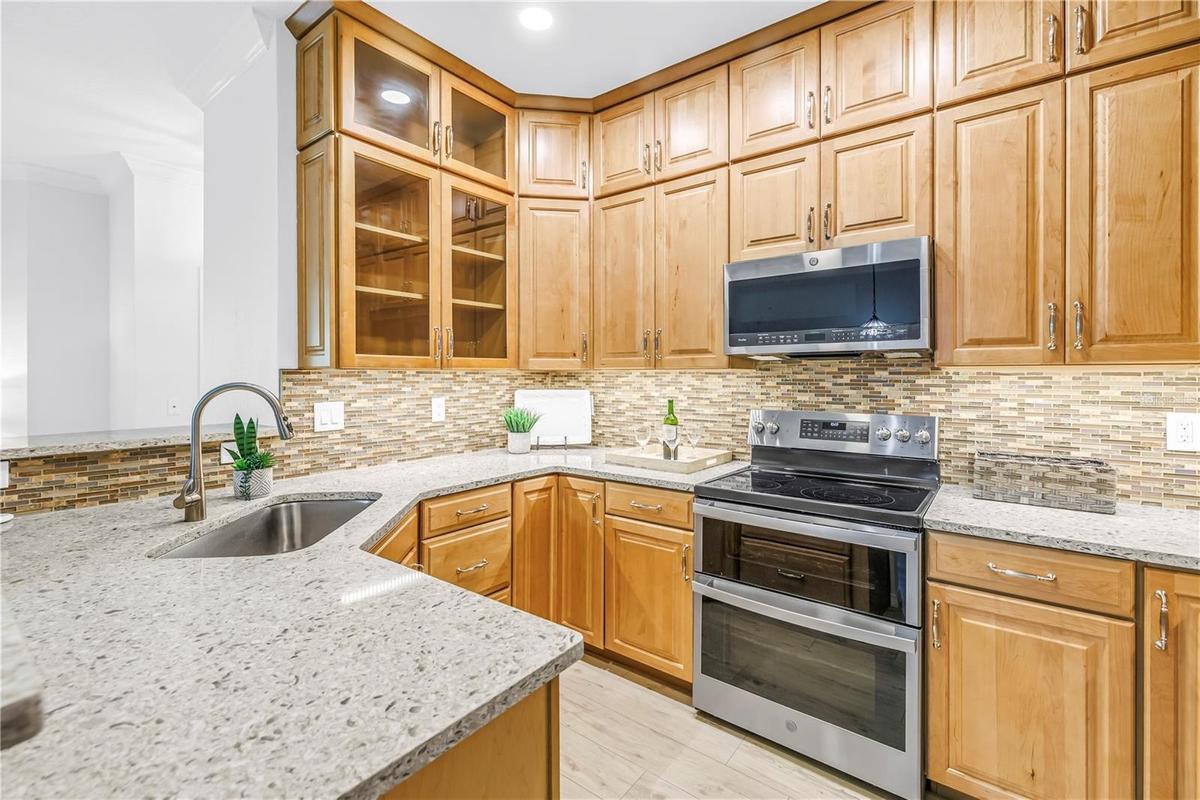 Updated kitchen features solid wood cabinetry, granite countertops, tile backsplash and stainless steel appliances.