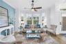 Bright and inviting living room features a bay window, luxury vinyl plank flooring and a remote-controlled sun shade.