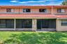 Screened lanai opens onto a shared green space.