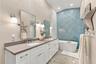 Beautifully updated primary bath featuring a freestanding soaking tub and elegant modern finishes.