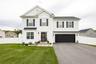 Two-story residence featuring white siding, black shutters, a two-car garage, and a fenced backyard