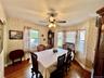 Hardwood flooring, curved wall with multiple windows, ceiling fan with integrated lighting