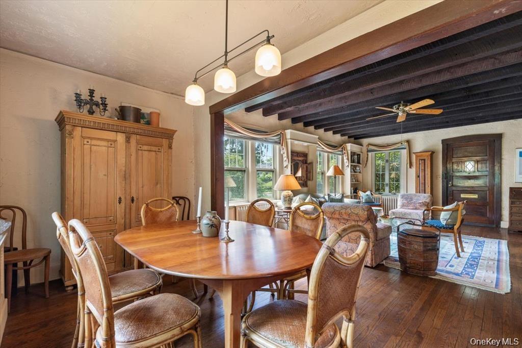 Dining area with hardwood / wood-style floors, beamed ceiling, and ceiling fan