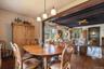 Dining area with hardwood / wood-style floors, beamed ceiling, and ceiling fan