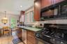 Kitchen featuring black appliances, a sink, backsplash, light tile patterned flooring, and recessed lighting