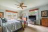 Carpeted bedroom with vaulted ceiling, radiator heating unit, and ceiling fan