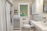 Full bathroom with tile walls, radiator heating unit, toilet, tile patterned flooring, and shower / bath combo