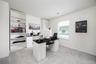 Built-in shelving units, white painted walls, window with blinds, light gray carpet flooring