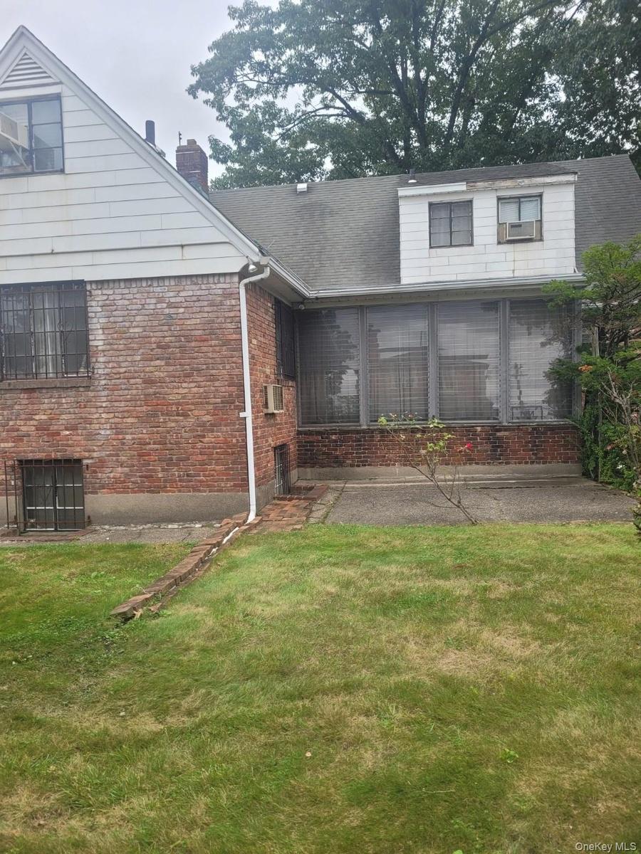 Brick and siding exterior with a pitched roof and enclosed patio