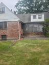 Brick and siding exterior with a pitched roof and enclosed patio