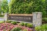 Virtually Edited. Stone pillar entrance sign for "The Colony Club" featuring integrated lighting and natural landscaping.