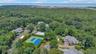 Expansive aerial perspective showcasing a residential community surrounded by dense tree cover.