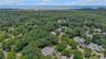Aerial perspective showcasing a residential community surrounded by abundant mature trees.