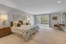 Light-filled room featuring a brand-new plush carpeting, recessed lighting, and a sliding glass door opening to an outdoor deck.