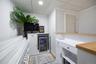 Built-in bar area featuring white cabinetry, light wood-finish countertops, and an integrated beverage refrigerator