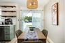 Vinyl plank flooring, light green cabinetry, white subway tile backsplash, white countertops, and a full-light patio door