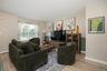 Light vinyl plank flooring, two-tone wall treatment, and a large window with blinds