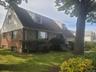 Brick and shingle exterior with a gabled roofline and dormer windows