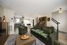 Open-concept living area with vinyl plank flooring, a built-in staircase, and recessed lighting