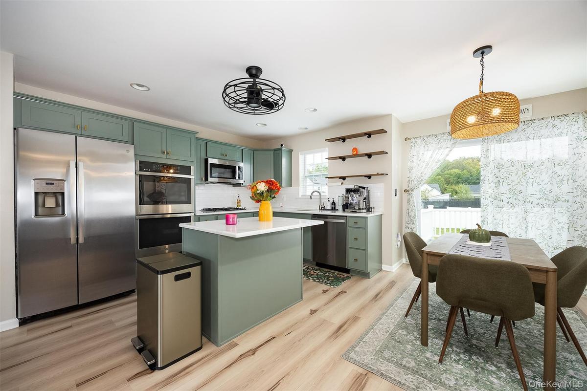 Light vinyl plank flooring, recessed lighting, and a sliding glass door