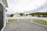 Spacious deck with gray composite decking, white railing, and sliding glass door