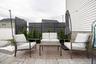 Paver patio with a circular inlay, white siding, and privacy screens
