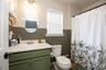 Bathroom featuring a single vanity with an integrated sink, a built-in toilet, and wood-finish flooring
