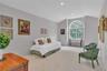 Spacious room featuring a large arched window, vaulted ceiling, recessed lighting, walk in closet and neutral carpet flooring.