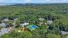 Aerial perspective showcasing a residential community nestled within lush tree-lined surroundings.