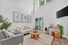 Living room featuring light wood finished floors and a towering ceiling