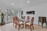 Bright dining area featuring a three-panel window, recessed ceiling lighting, and wood floors.