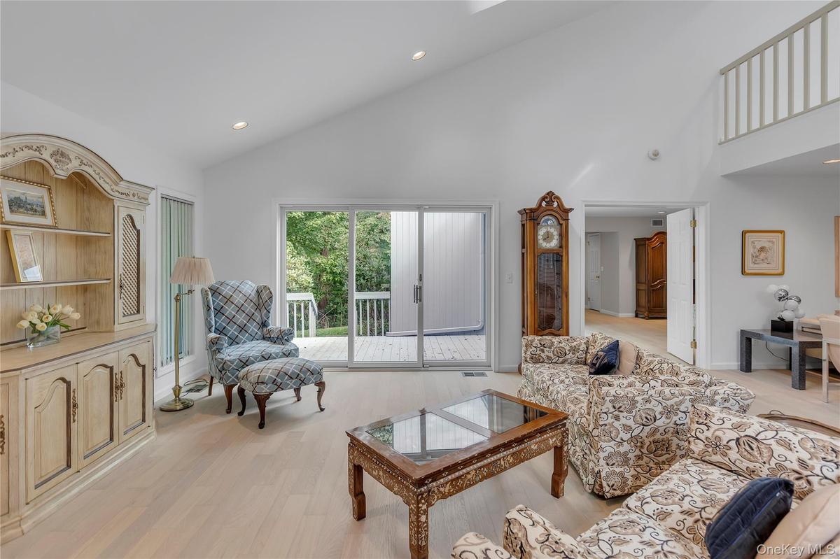 Spacious living area featuring a vaulted ceiling and recessed lighting.