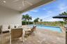 Covered patio with recessed lighting and a ceiling fan, opening to a paver deck