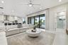 Open concept living area with recessed lighting, ceiling fan, large format tile flooring, and sliding glass doors to the exterior