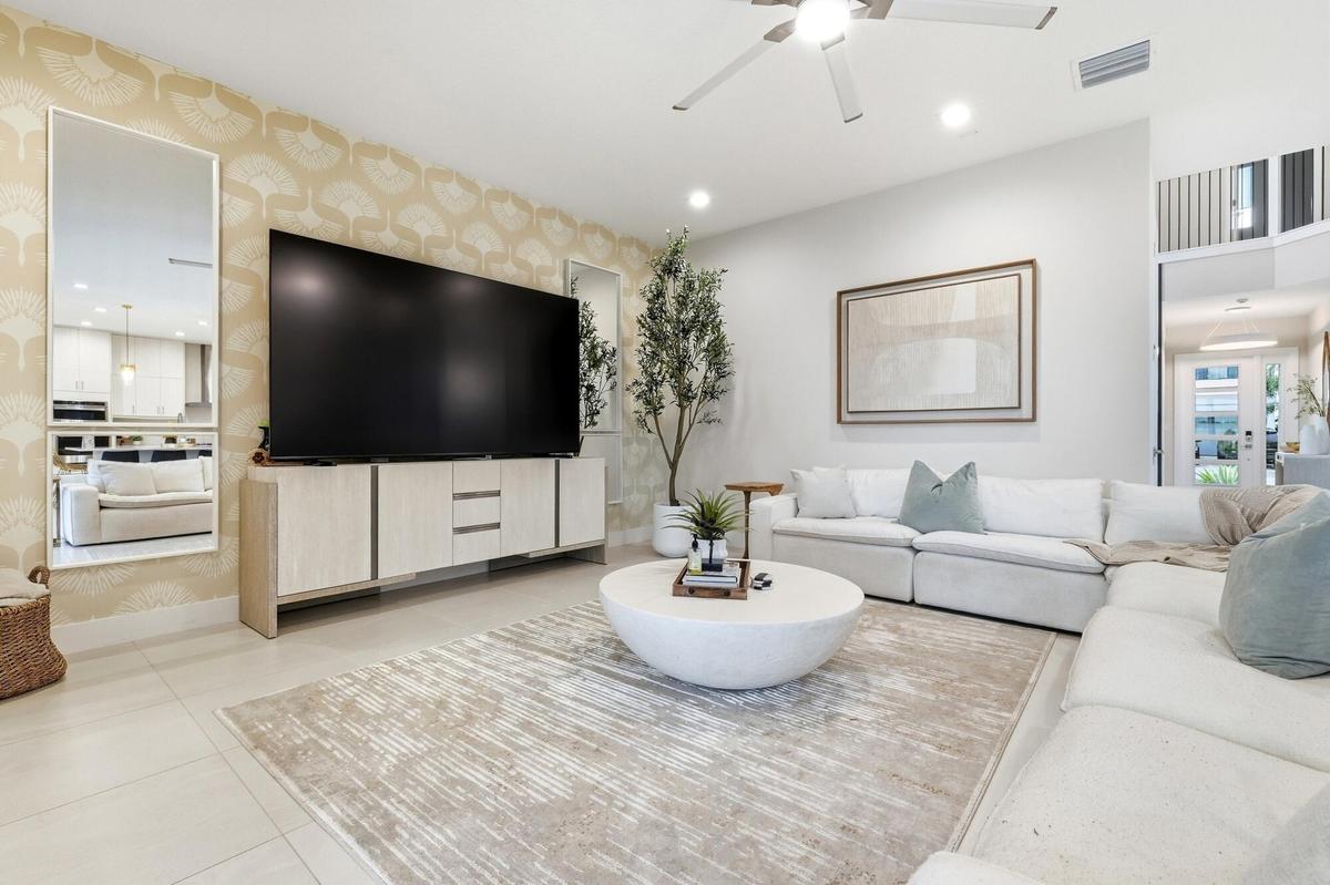 Recessed ceiling lighting, a modern ceiling fan, tall ceilings, and light-toned tile flooring