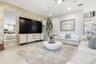 Recessed ceiling lighting, a modern ceiling fan, tall ceilings, and light-toned tile flooring