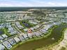 Residential community featuring a curved street pattern, multiple ponds with fountains, and an expansive surrounding greenbelt