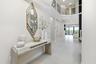 Two-story entry foyer featuring large format tile flooring and a second-story balcony with metal railings