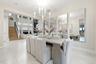 Open-concept dining area featuring a light-toned dining table and white tile flooring