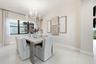 Recessed lighting, large window with dark trim, light-toned wall paint, contemporary chandelier, and light-toned tile flooring