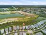 Aerial perspective of a residential community featuring waterways, established homes, and undeveloped land