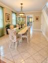 Tile flooring with contrasting border, crown molding, and a chandelier lighting fixture
