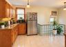 Wood-finish cabinetry, stone countertops, tile flooring, and a glass block architectural feature