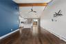 Dark wood-finish flooring with a contrasting blue accent wall